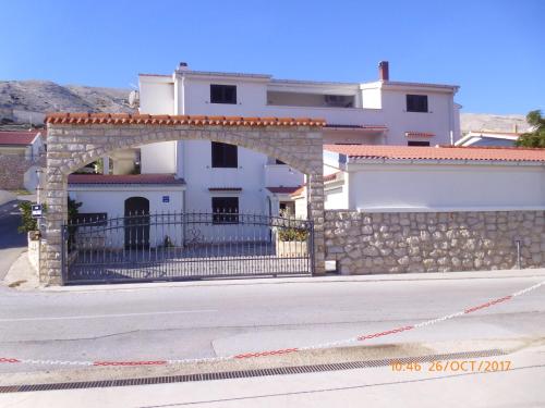 a building with an arch and a stone wall at Apartments Lidija in Pag
