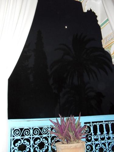 a night view of a balcony with palm trees at Palais Riad Hida in Oulad Berhil