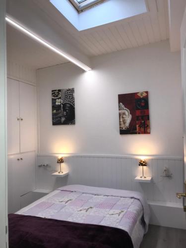 a bedroom with white walls and a bed with two lights at Perdiu 52 Confortable in Pas de la Casa