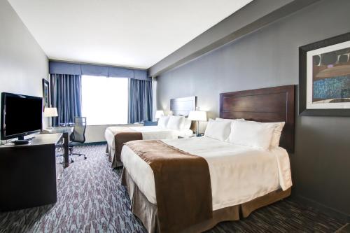 a hotel room with two beds and a flat screen tv at Best Western Plus Brandon Inn in Brandon