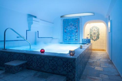 uma grande banheira num quarto com luz azul em San Francesco Resort em Agropoli