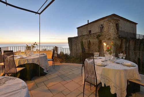 a table set up on a patio with the ocean in the background at San Francesco Resort in Agropoli