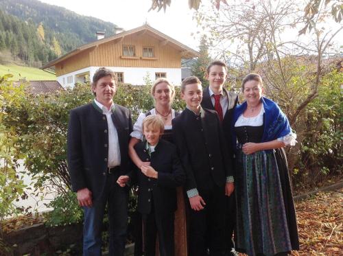 a family posing for a picture in front of a house at Landgasthof Dorferwirt in Oberau
