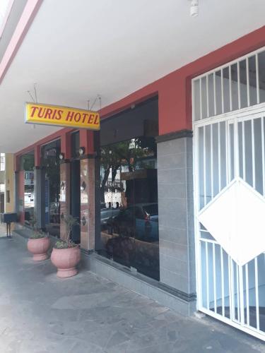 a tines hotel with a sign on the front of it at Turis Hotel in Santo Ângelo