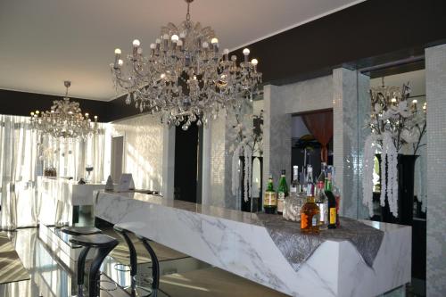 eine Bar in einem Zimmer mit Kronleuchtern in der Unterkunft Hotel In - Lounge Room in Cazzago di Pianiga