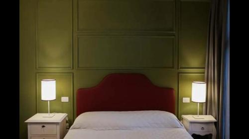 a bedroom with a bed and two night stands with lamps at Agriturismo Casanova di Nardini in Scandicci