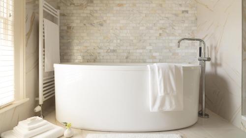 a white bath tub in a bathroom with a towel at 33 Main in Lenox