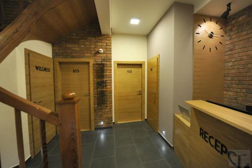 a hallway with doors and a clock on the wall at Apartmány Kukučín in Košice