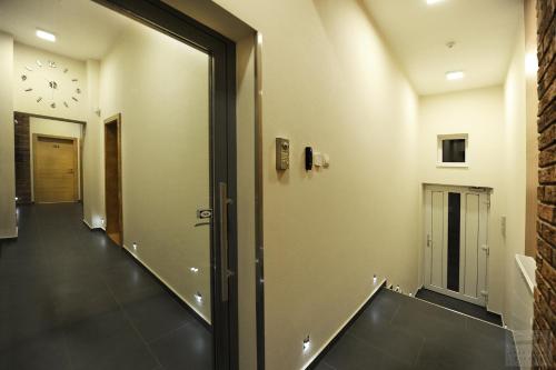 a hallway with a mirror and a clock on the wall at Apartmány Kukučín in Košice