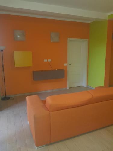 a living room with an orange couch and a white door at Surf House Cabo Verde in Santa Maria