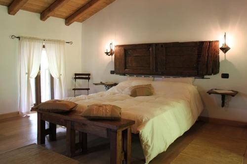 een slaapkamer met een groot bed met een houten hoofdeinde bij Agriturismo Grassi Lunghi in Pasturo