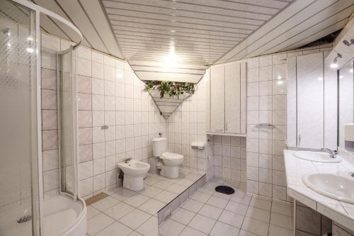 a white bathroom with a toilet and a sink at Golden Lion Guest Rooms Szewska 19 in Kraków