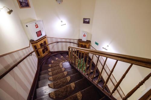a stairway with a wooden railing and a staircase at Golden Lion Guest Rooms Szewska 19 in Kraków