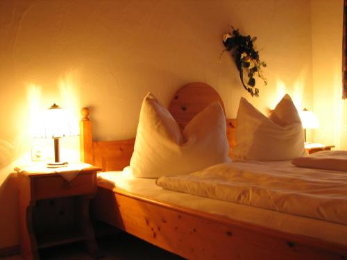 a bedroom with a bed with pillows and a lamp at Appartement Lotte Familie Grünberger in Brixen im Thale