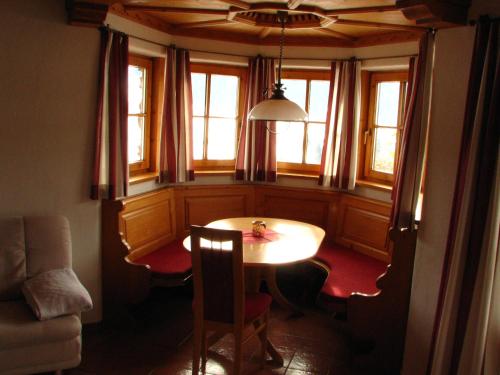 a dining room with a table and chairs and windows at Appartement Lotte Familie Grünberger in Brixen im Thale