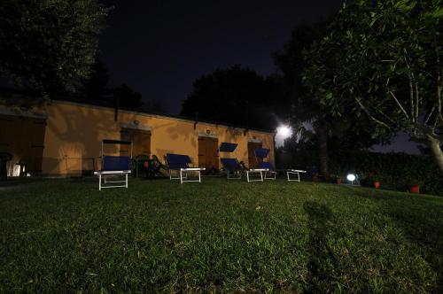 a group of chairs sitting in a yard at night at Poggio del Conero in Poggio