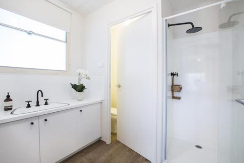 a white bathroom with a sink and a shower at Twiggy @ Anglesea in Anglesea