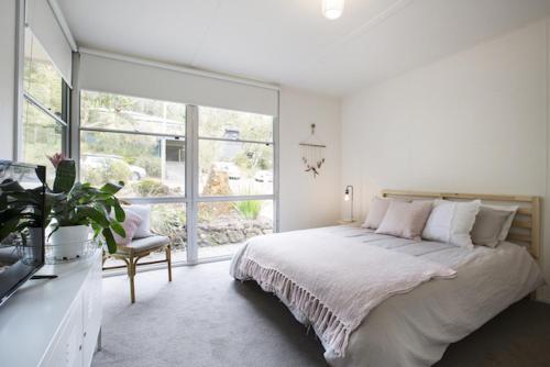 a bedroom with a bed and a large window at Twiggy @ Anglesea in Anglesea