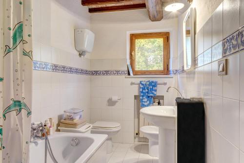 a white bathroom with a sink and a toilet at Appartamento Il Tiglio in Trequanda