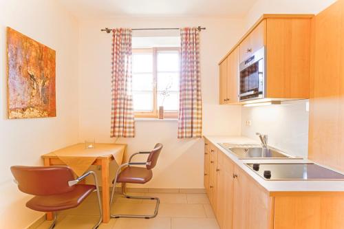 a kitchen with a sink and a table and chairs at Frühstückspension Herzog zu Laah in Linz