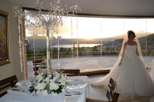 a woman in a wedding dress standing in front of a table at Hotel Medina Del Lago in Otavalo