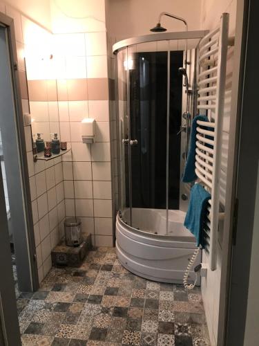 W łazience znajduje się wanna i prysznic z niebieskimi ręcznikami. w obiekcie VaBank Apartamenty w centrum w Zielonej Górze