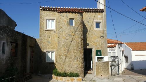 a large stone building with a door in a street at Castelinho da Azóia - Checkinhome in Sintra