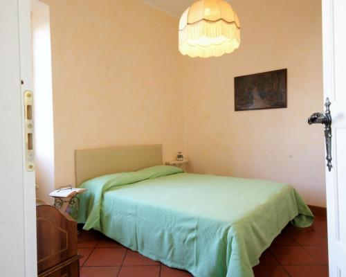 ドルチェードにあるCasa del mulino 1のベッドルーム(緑のベッド1台、シャンデリア付)