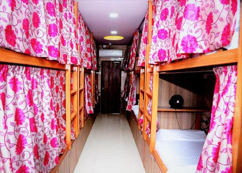 a corridor of a bus with red and white curtains at Delta Dormitory in Mumbai