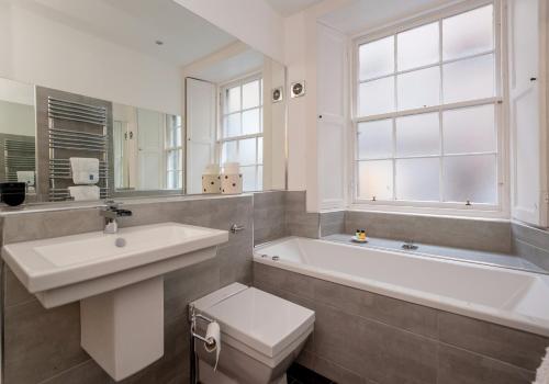 ein Badezimmer mit einer Badewanne, einem Waschbecken und einem WC in der Unterkunft Parliament Sq (apt 3) Royal Mile in Edinburgh