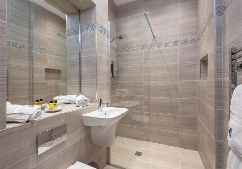 a bathroom with a sink and a glass shower at Castle Suite 2 Old Town in Edinburgh