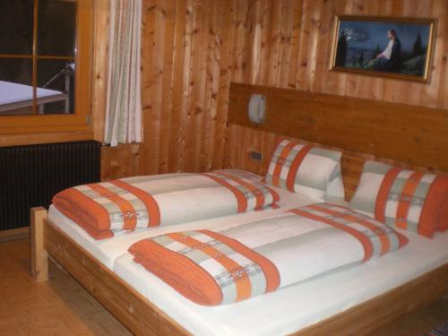 a bedroom with two beds in a wooden room at Hoazhof in Kals am Großglockner
