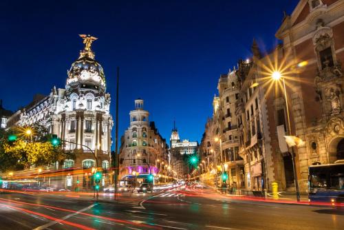 una calle de la ciudad por la noche con edificios y luces de la calle en Chueca Gran Via Apartaments TPH, en Madrid