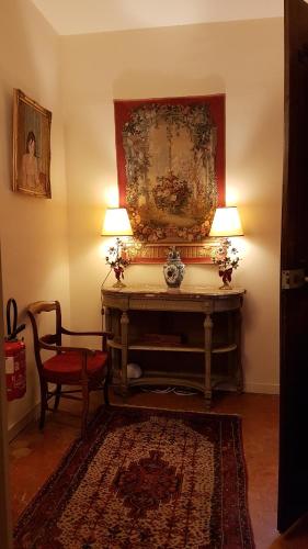 a room with a table and two lamps and a chair at Hotel Cardinal in Aix-en-Provence