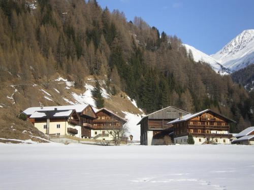 a group of buildings on a snow covered mountain at Hoazhof in Kals am Großglockner