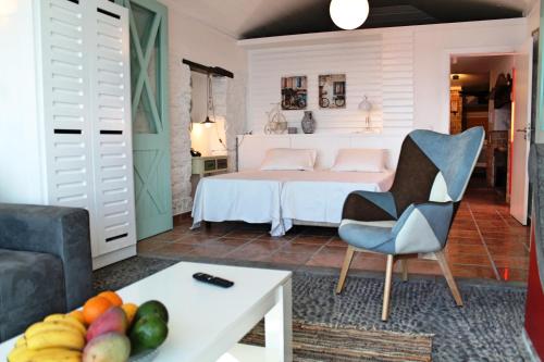 un soggiorno con letto e tavolo con frutta di OurMadeira - Cottage do Mar, secluded ad Arco da Calheta