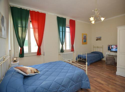 a bedroom with a blue bed and red curtains at Terra d' Arezzo in Arezzo