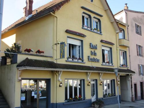 a yellow building with flowers in the window at Hotel de la Londaine in Champagnole