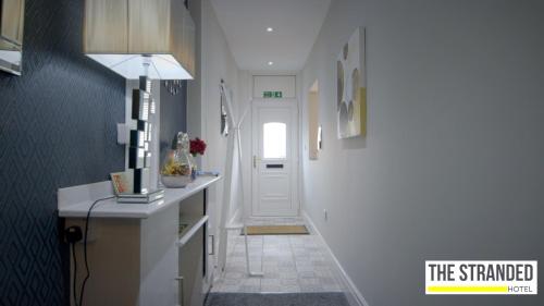 a hallway with a white door and a white counter top at The Stranded Hotel in Blackpool