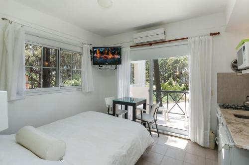 a bedroom with a bed and a table with a television at Colina Blanca Apart in Mar de las Pampas