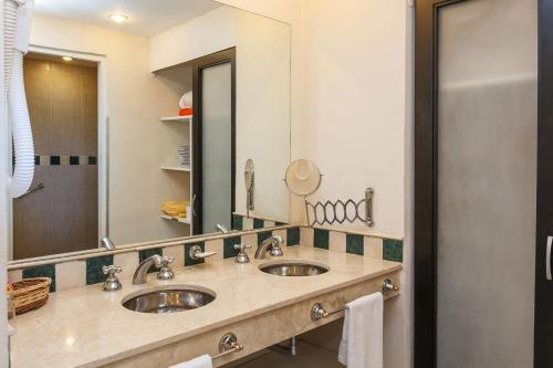a bathroom with two sinks and a large mirror at Colina Blanca Apart in Mar de las Pampas