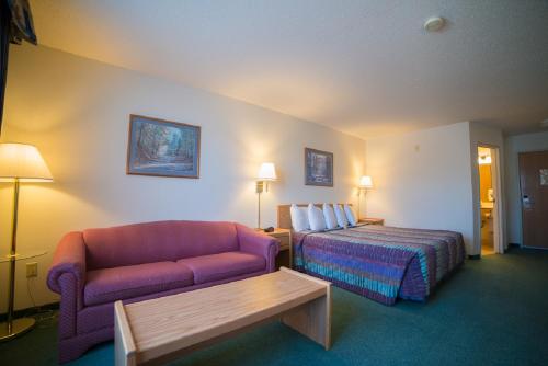 a hotel room with a bed and a couch at River Valley Inn & Suites in Osceola