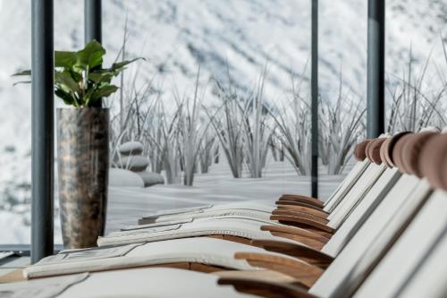 a row of white benches in front of a window at SKI - GOLF - WELLNESS Hotel Riml in Hochgurgl