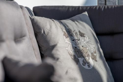 a gray pillow with a design on it on a couch at SKI - GOLF - WELLNESS Hotel Riml in Hochgurgl