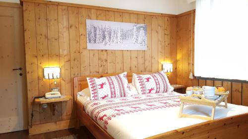 a bedroom with a large bed with wooden paneling at Hotel Villa Gaia in Cortina dʼAmpezzo