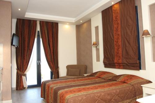 a hotel room with a bed and a chair at Frini Studios in Plomarion