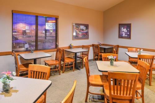 a restaurant with tables and chairs and a window at Baymont by Wyndham Sioux Falls North,I-29,Russell St, Airport in Sioux Falls