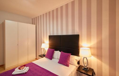 una camera da letto con un letto con cuscini rosa e 2 lampade di Alcam Calabria a Barcellona