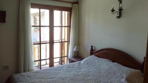 1 dormitorio con cama y ventana grande en Aldea de Montaña 1 - Andarlibre en San Martín de los Andes