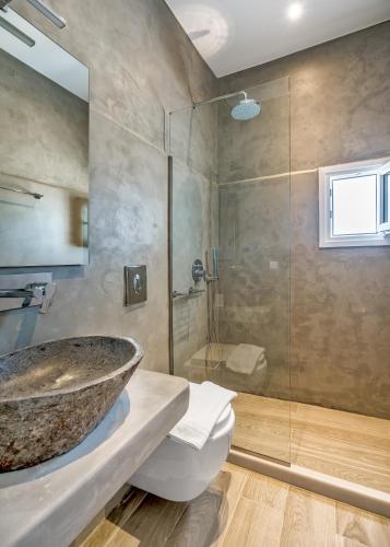 a bathroom with a sink and a glass shower at Cape Mykonos in Mýkonos City
